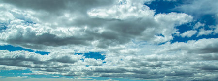 Wide shot panoramic cloudscape with lost of clouds and blue sky backgroundの写真素材