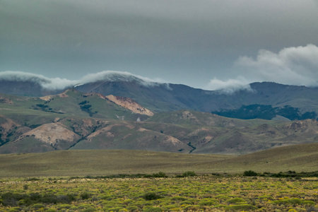 Andes mountains covered by big white clouds at top, cushamen department, chubut province, argentinaの写真素材