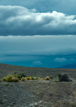 Andes mountains covered by big white clouds at top, cushamen department, chubut province, argentinaの写真素材