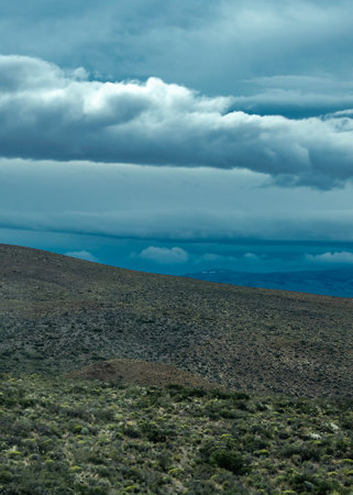 Andes mountains covered by big white clouds at top, cushamen department, chubut province, argentinaの写真素材
