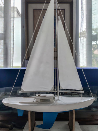 Wooden small-scale model crafted miniature of sailboat located over table at interior house room