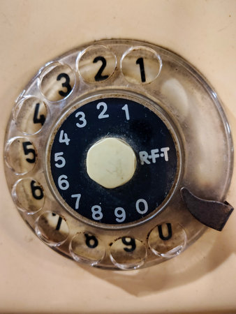 Close-up, front view of an old rotary telephone dial with visible numbers.の写真素材