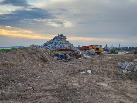 Wide shot of a construction site with a pile of rocks and scrap metal under a cloudy skyの写真素材