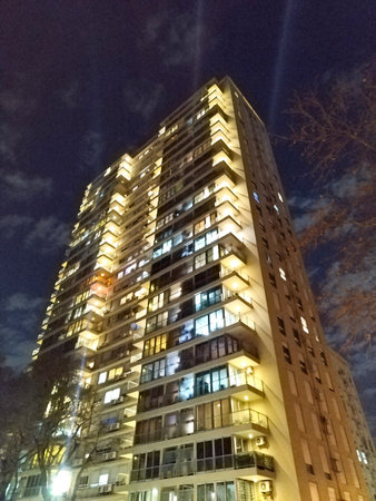 Tall vertical shot of modern residential apartment building at night sky background, montevideo city, uruguayの写真素材