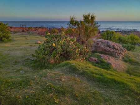 An eye-level, wide landscape shot of a serene coastline at dusk or dawn.の写真素材