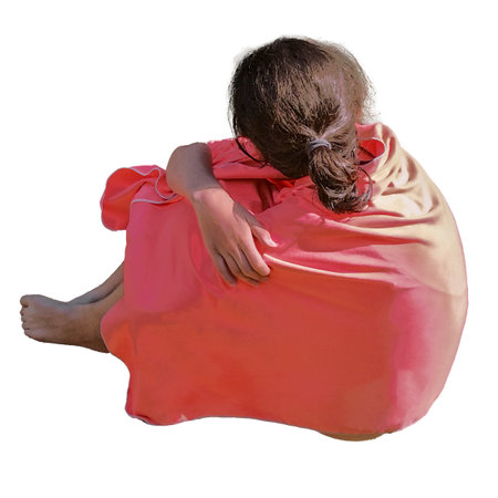 A medium, high angle view shot of a teen woman wrapped in a blanket isolated photoの写真素材