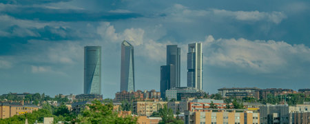 Telephoto view of a modern city skyline with several tall buildings rising above a mid-rise urban zone.の写真素材