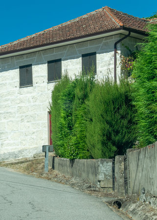 Frontal view of a narrow village street lined with traditional stone walls and whitewashed houses.の写真素材