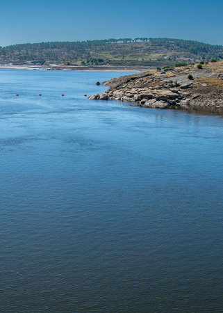 Wide shot of a river crossing a dry valley, flanked by hills.の写真素材