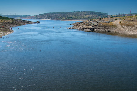 Wide shot of a river crossing a dry valley, flanked by hills.の写真素材