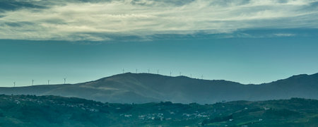Medium-long shot of rolling hills under a dramatic sky with streaked clouds.の写真素材