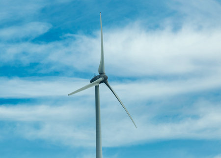 Low-angle shot of a single wind turbine against a cloudy skyの写真素材