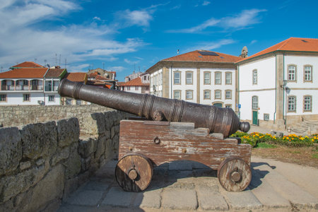 Medium shot of a vintage cannon on a rustic wooden carriage, situated on the battlements of chaves castle,  portugal.の写真素材