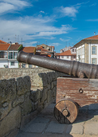Medium shot of a vintage cannon on a rustic wooden carriage, situated on the battlements of chaves castle,  portugal.の写真素材