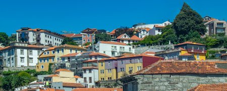 High angle wide shot of Porto hillside neighborhood filled with terracotta roofed traditional...
