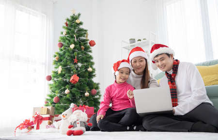Happy Asian family using a laptop for shopping online in Christmas Dayの写真素材
