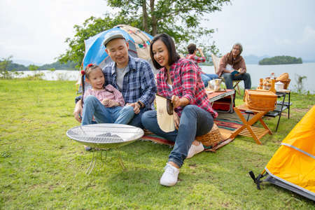 multi generation family on camping trip by lake together.travelvacations and life conceptの写真素材