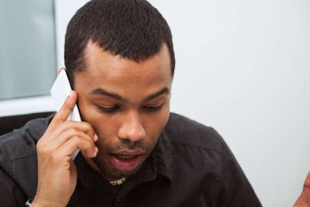 Portrait of successful businessman working in his office and having phone conversation.の写真素材