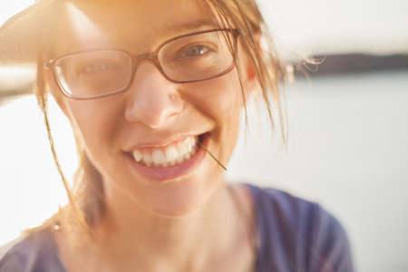 Close up portrait of beautiful girl with eyeglasses looking at cameraの写真素材
