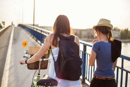 Two girls walking across the bridge. Enjoying spring time.の写真素材