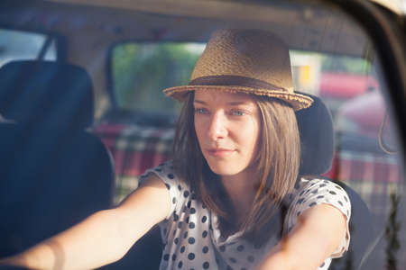 Retro style woman driving old timer car.