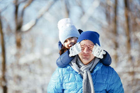 father and daughter playing in the snow in winter
