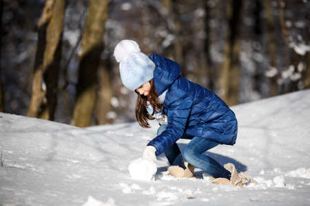 Little girl outdoors on beautiful winter snow dayの写真素材