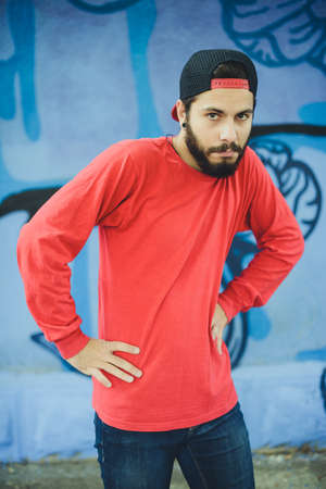 Young man  dances with a graffiti in the backgroundの写真素材