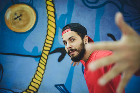 Young man  dances with a graffiti in the background