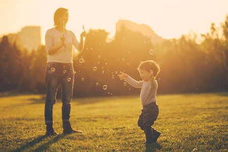 Mom and son have fun and make balloons from soapの写真素材