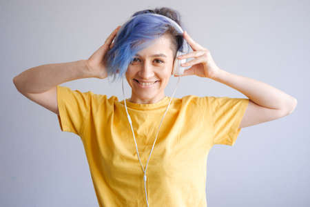 Rock style woman with headphones listening to music