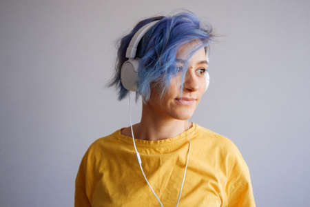 Rock style woman with headphones listening to musicの写真素材