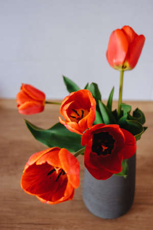 Bouquet of tulips in vase on wooden tableの写真素材
