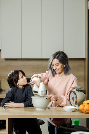 Mother and her son preparing breakfast together in the kitchen at home.の写真素材