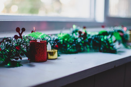 sparkling LED candles and tinsel decorations along a ledgeの写真素材