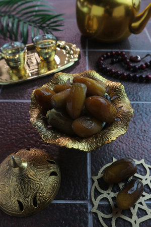 Ramadan Kareem concept, dates in a golden bowl on the table