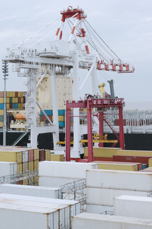 Large harbor crane loading containers on a a large cargo vesselの写真素材