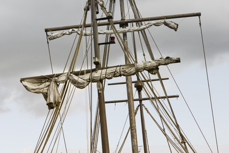 Detail of a mast of a ship. Masting of big wooden sailing ship, detailed rigging with sails