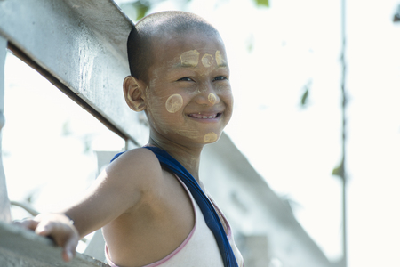Smiling Burmese boy with circles of tanakha painted on his face. February 22, 2014 - Yangon, Myanmarのeditorial素材
