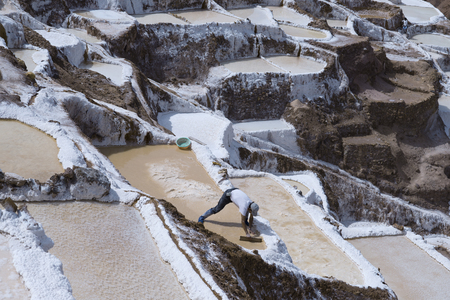 Worker extracting manually salt from the Maras salt ponds located at the Peru's Sacred Valley. October 18, 2012 - Maras, Peruのeditorial素材