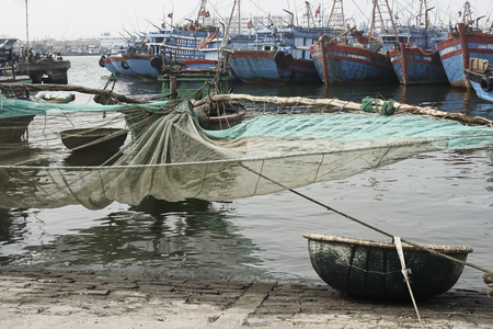 Traditional Fishing Boat with Net and Woven Bamboo Basket Boat At The Fishing Village in Da Nang. December 26, 2013 - Da Nang, South Vietnamのeditorial素材