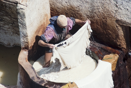 Worker Processing Hides In a White Tanning Pool At A Traditional Leather Tannery, Fes, Moroccoのeditorial素材