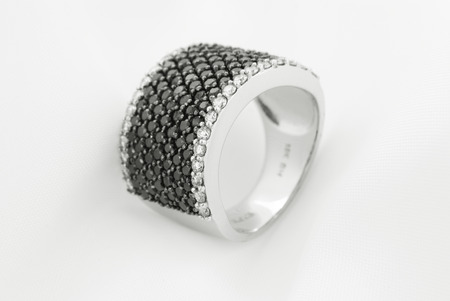 White Gold Ring With Black Diamonds On Soft Backgroundの写真素材
