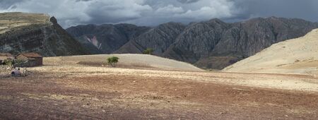 Scenic Panoramic Landscape At Maragua Dormant Volcano. Red Soil Rich In Volcanic Ash  And A Small House Looking Over The Maragua Syncline Mountain Range, Boliviaの写真素材