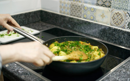 A home-cooked meal of green beans, carrots, and potatoes, freshly garnished with chopped herbsの写真素材