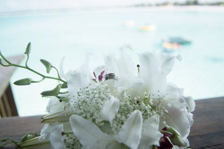 Wedding ring nestled in white bridal bouquetの写真素材