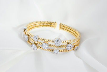 Luxurious gold bracelet with diamond accents presented on satin fabricの写真素材