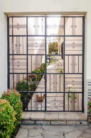 Abandoned stuffed bear in a stone walkway behind a gate.の写真素材