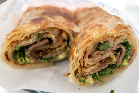 Taiwanese beef rolls - thinly sliced, braised beef, wrapped with sweet hoisin sauce in a crispy, flaky scallion pancake.の写真素材