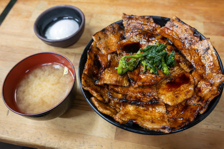A delicious Buta Don bowl featuring grilled pork slices glazed with a savory sauce, served on...